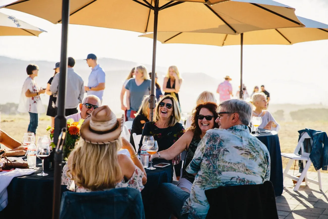 Guests at tables on the estate at golden hour
