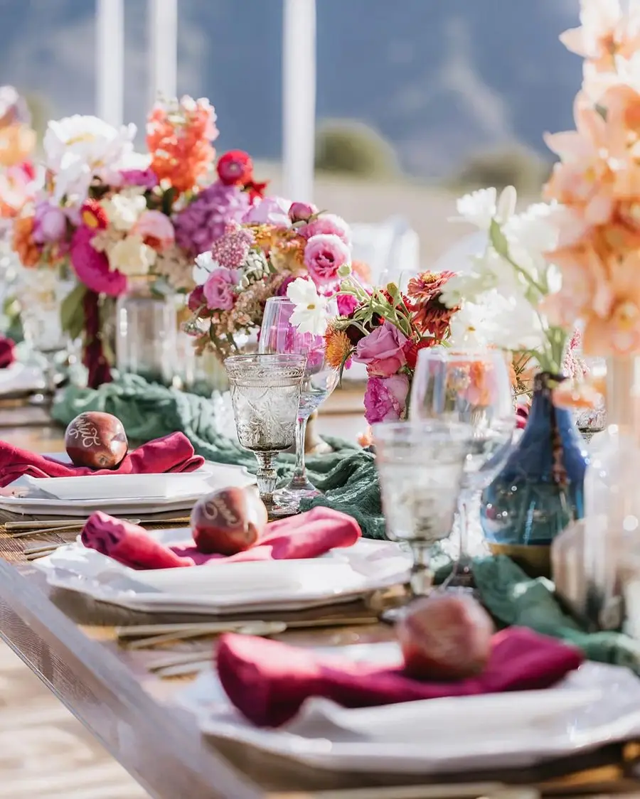 A tablescape of florals, velvet napkins, and inscribed pears