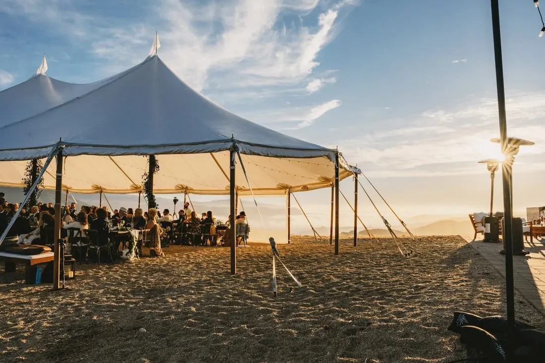 A sailcloth tent glowing at sunset on the ridge